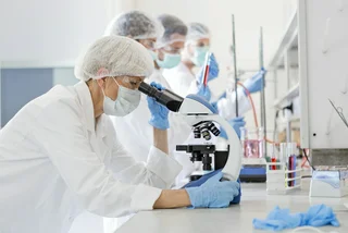 Scientists examine a virus in the laboratory, via iStock / Nastasic