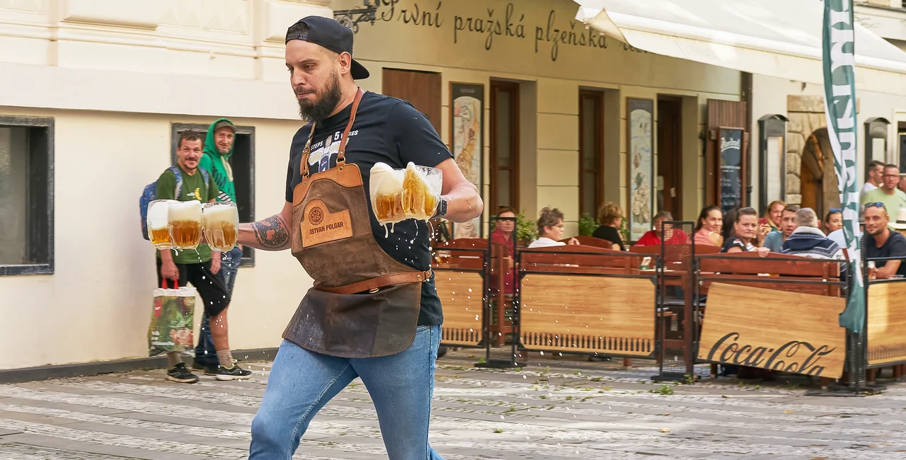 Prague waiter carrying beer at U Pinkasů's fastest waiter competition in October 2023. Photo: iStock / Heiko119