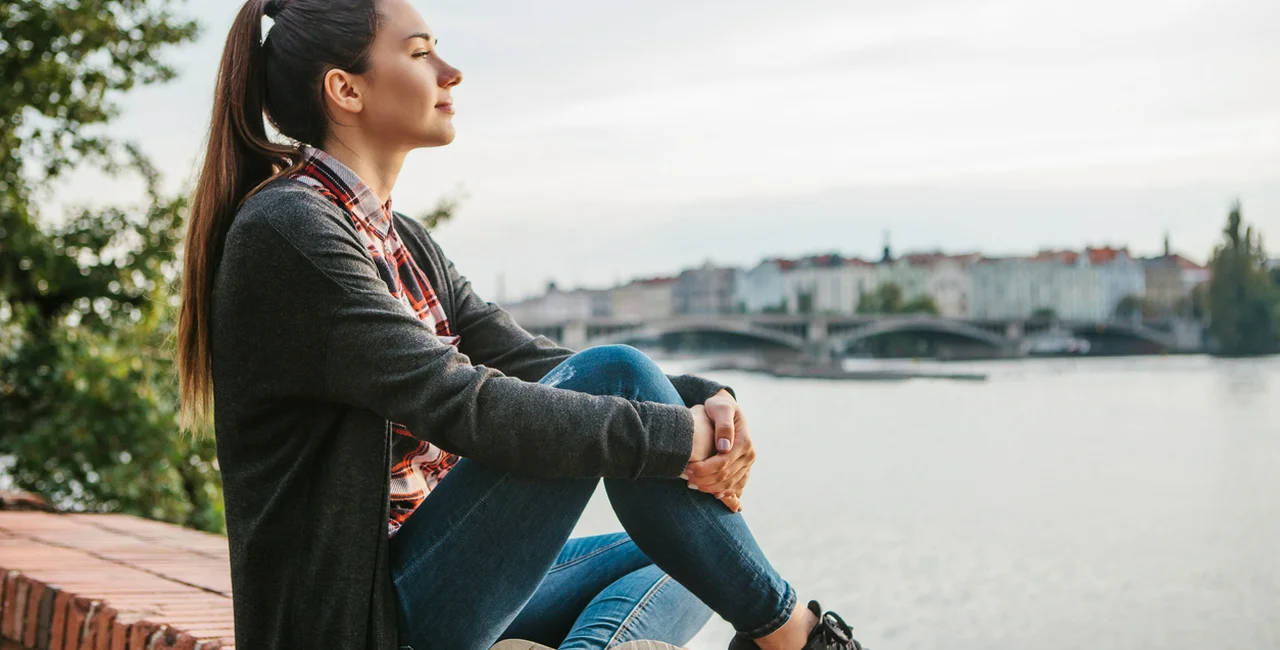 A young girl on the banks of the Vltava River in Prague