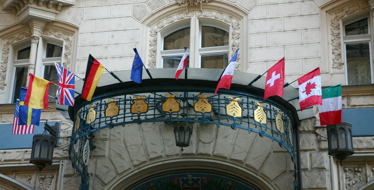 World flags line the entrance of a major international hotel in Prague