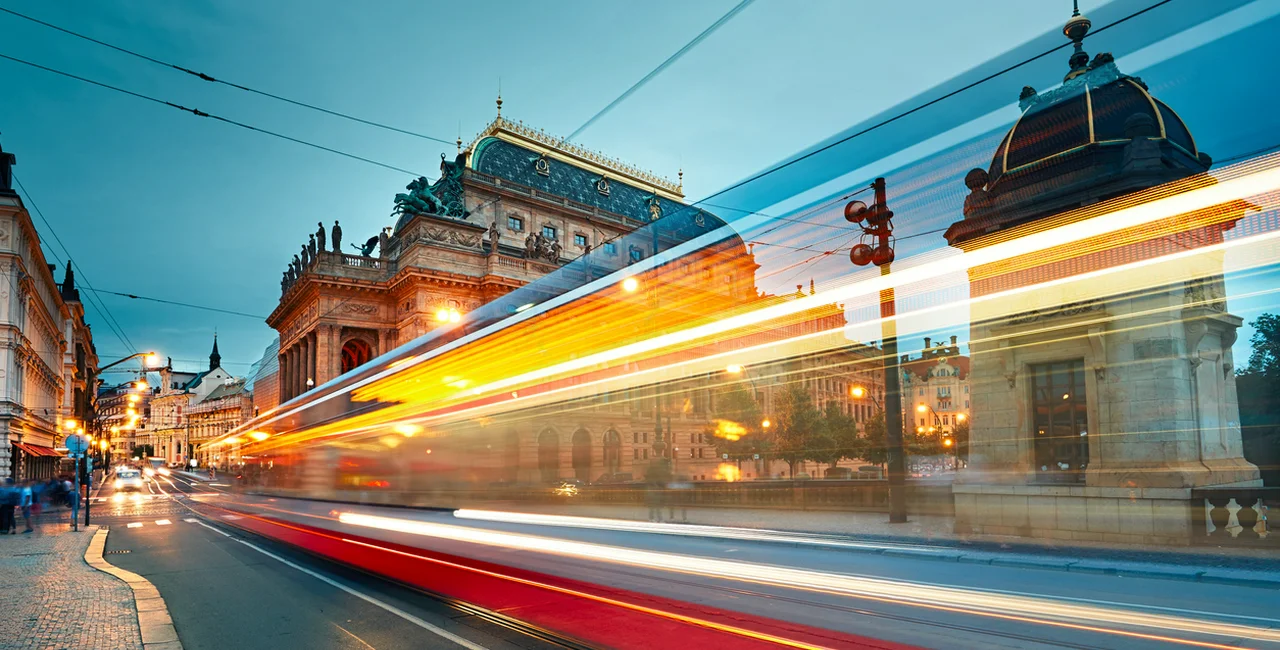 A Prague tram zooms by the city's National Theatre