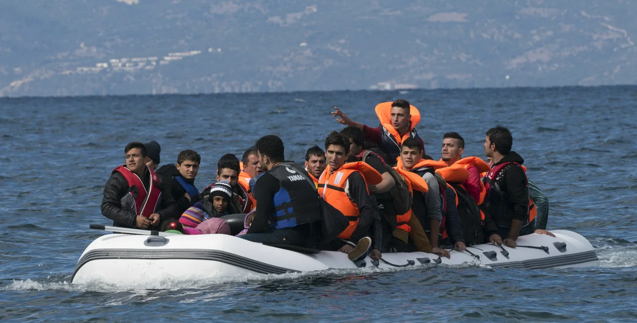 October 25, 2015: An inflatable boat filled with refugees and other migrants approaches the north coast of the Greek island of Lesbos (Illustrative image)
