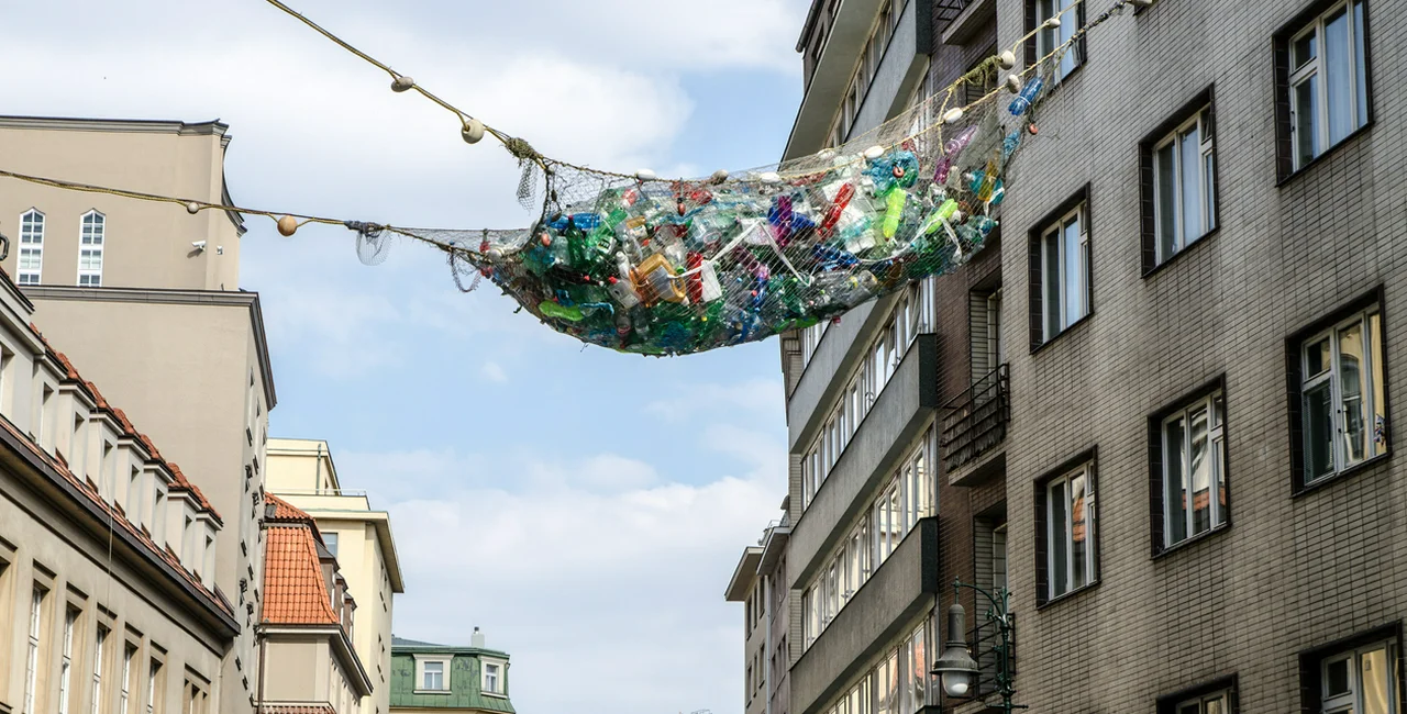 An art exhibit above Prague's Dlouhá street depicts  a fishing net full of plastic waste