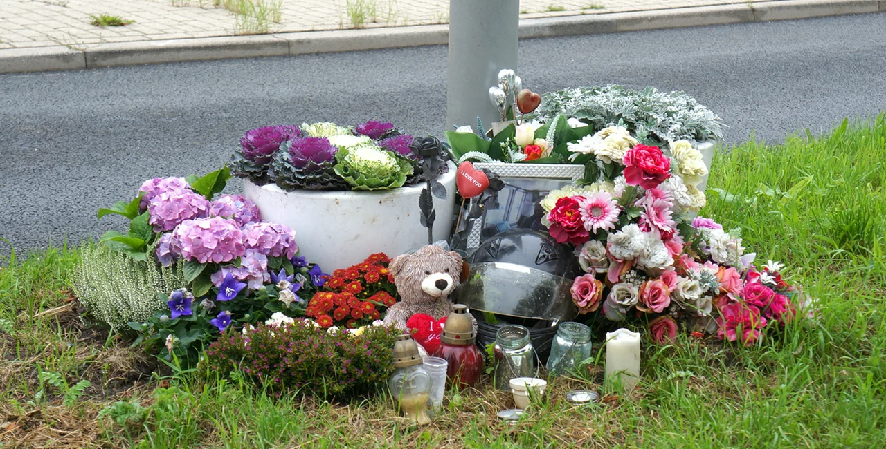 Memorial site with flowers on the side of the road to honor the victim of a traffic accident.