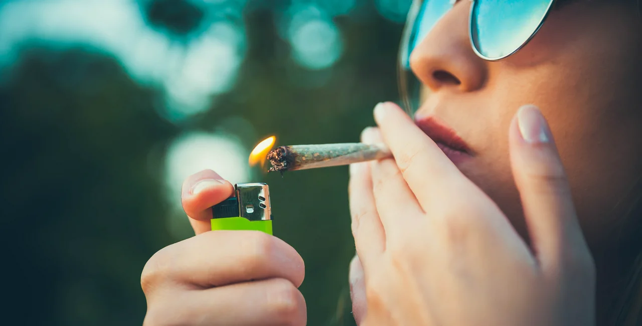 Young woman lighting up a marijuana joint (Illustrative photo)