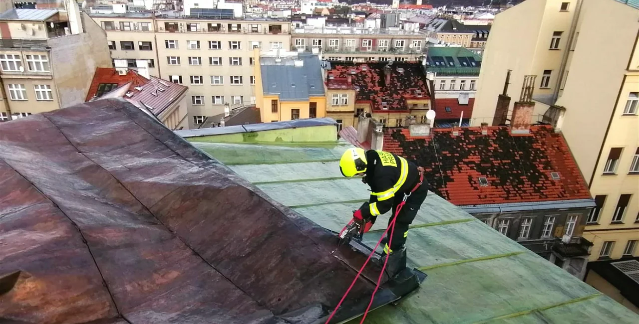 Firefighters secure a metal part of a roof. via Praha.EU