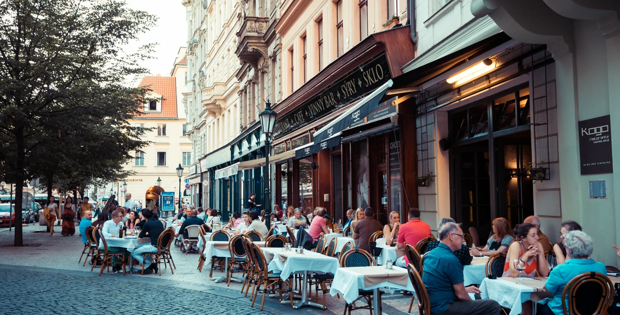 Patrons dining at an outdoor restaurant on Havelská street in Old Town, Prague 1