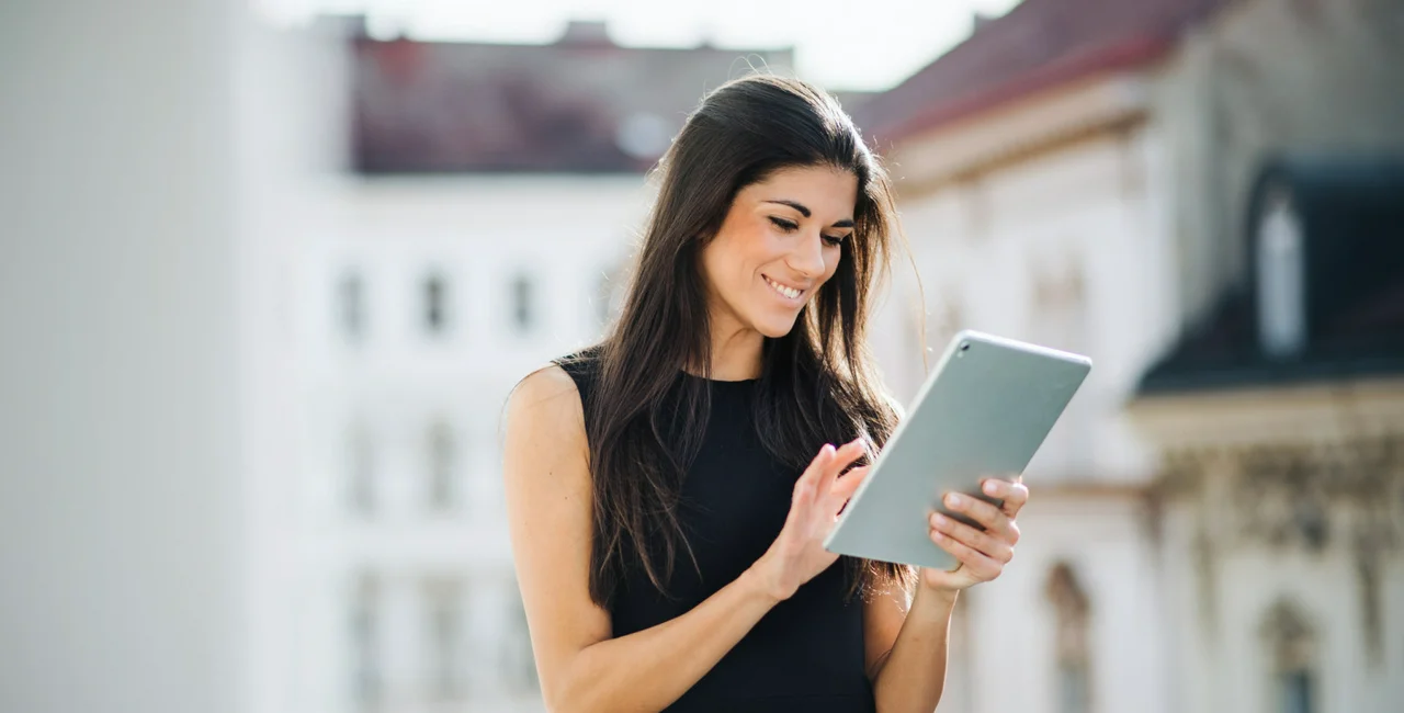 Young businesswoman with tablet standing on a terrace outside an office in city (iStock/ @Halfpoint)
