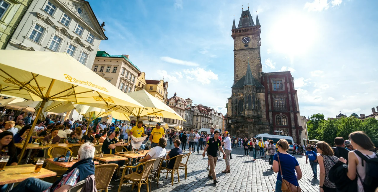 Tourists in Prague's Old Town Square enjoying a beer in 2015 via iStock / anouchka