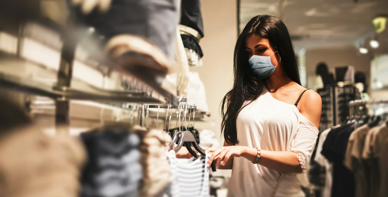 Young woman with face mask in department store via iStock / franckreporter
