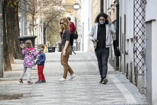 Children and adults wearing face masks on the streets of Prague