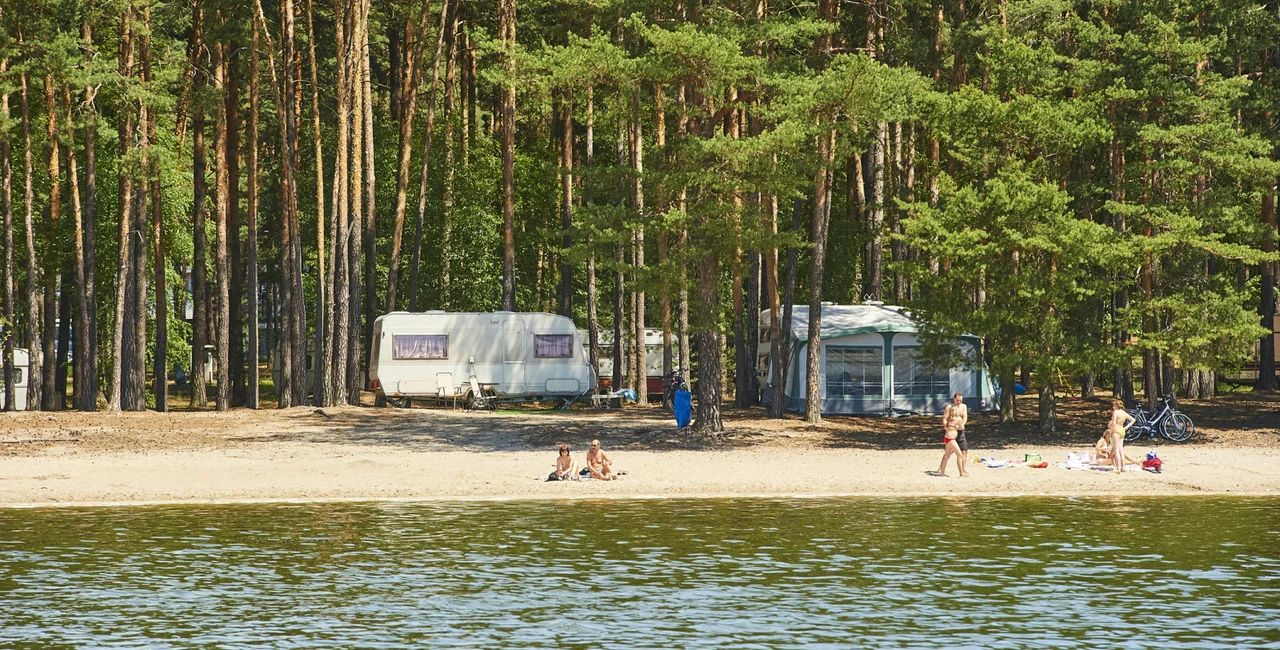 Macha Lake, Czech Republic - June 14, 2009: Beach on Macha Lake. Swimming and camping are popular summer tourist activities in Macha Lake tourist resort / iStock photo @PetrBonek