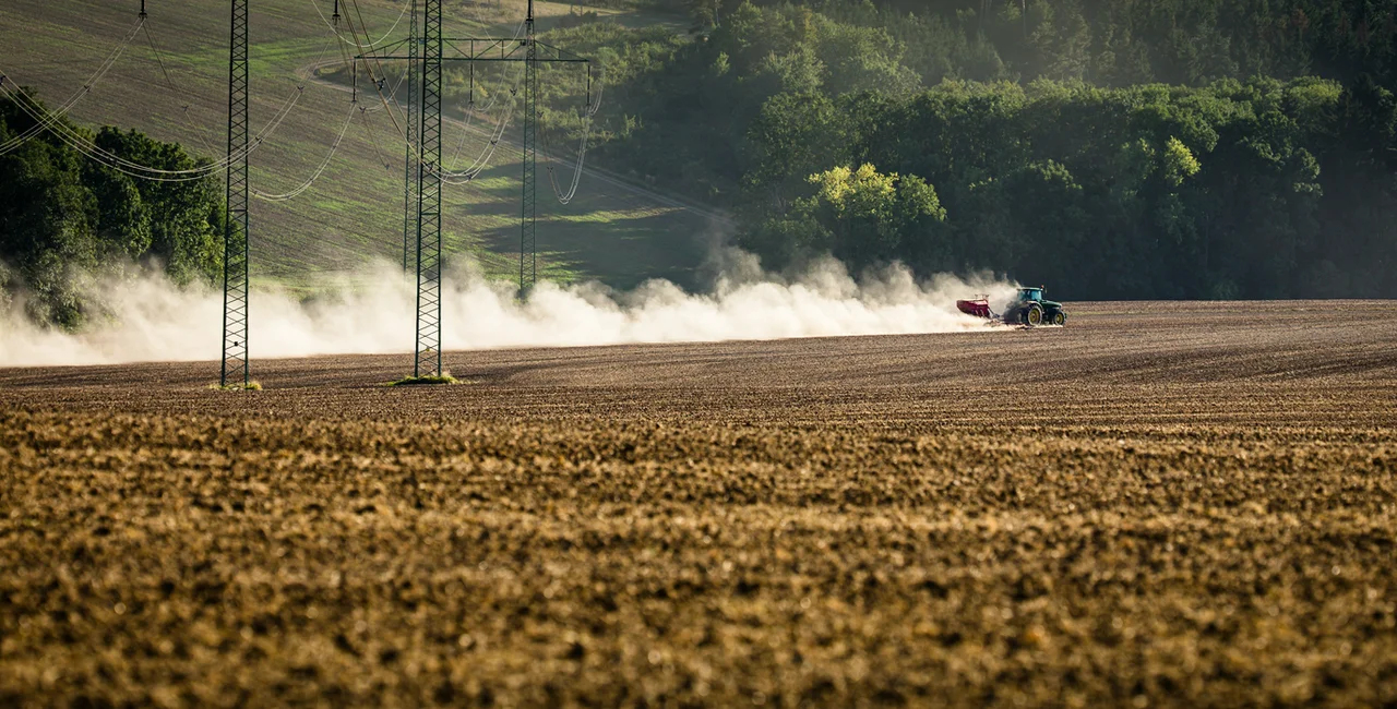 Tractor plowing a dry farm field in rural Czech Republic via iStock / ViktorCap