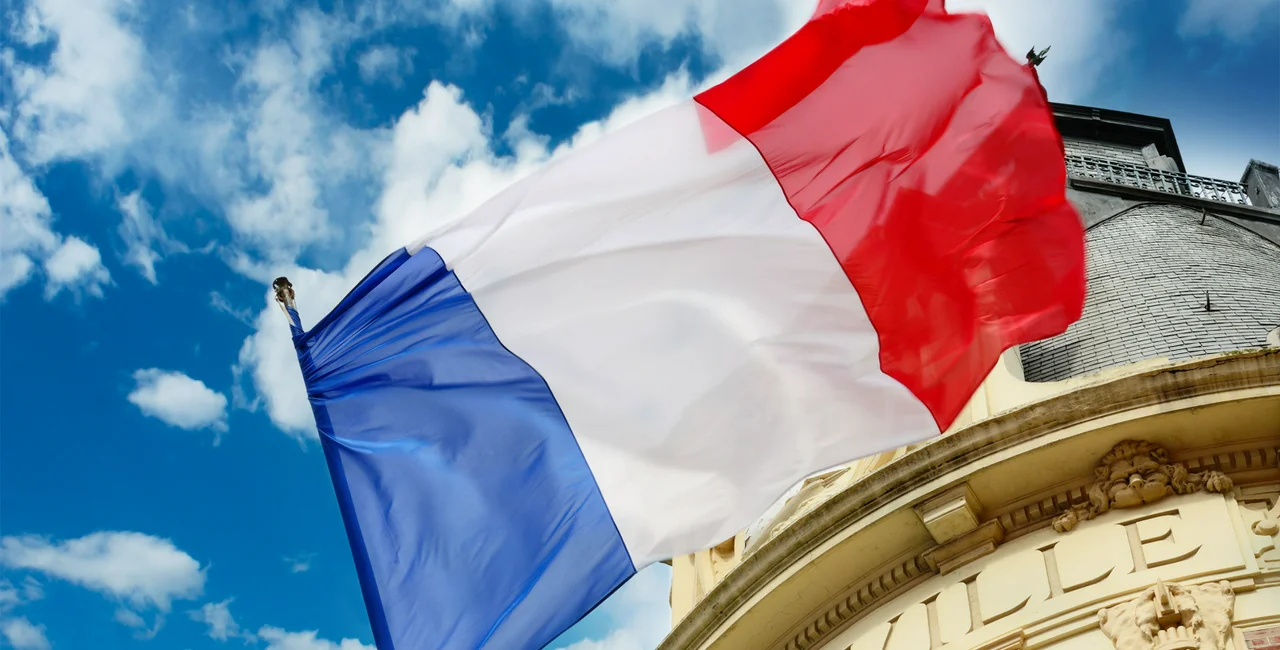 French flag waiving over some Hotel de Ville (iStock photo @Connel_Design)