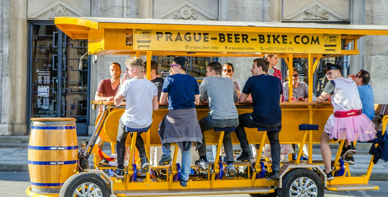 Tourists pedal a beer bike through the center of Prague