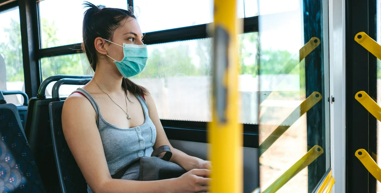 Young woman wearing a face mask on a bus via iStock / urbazon