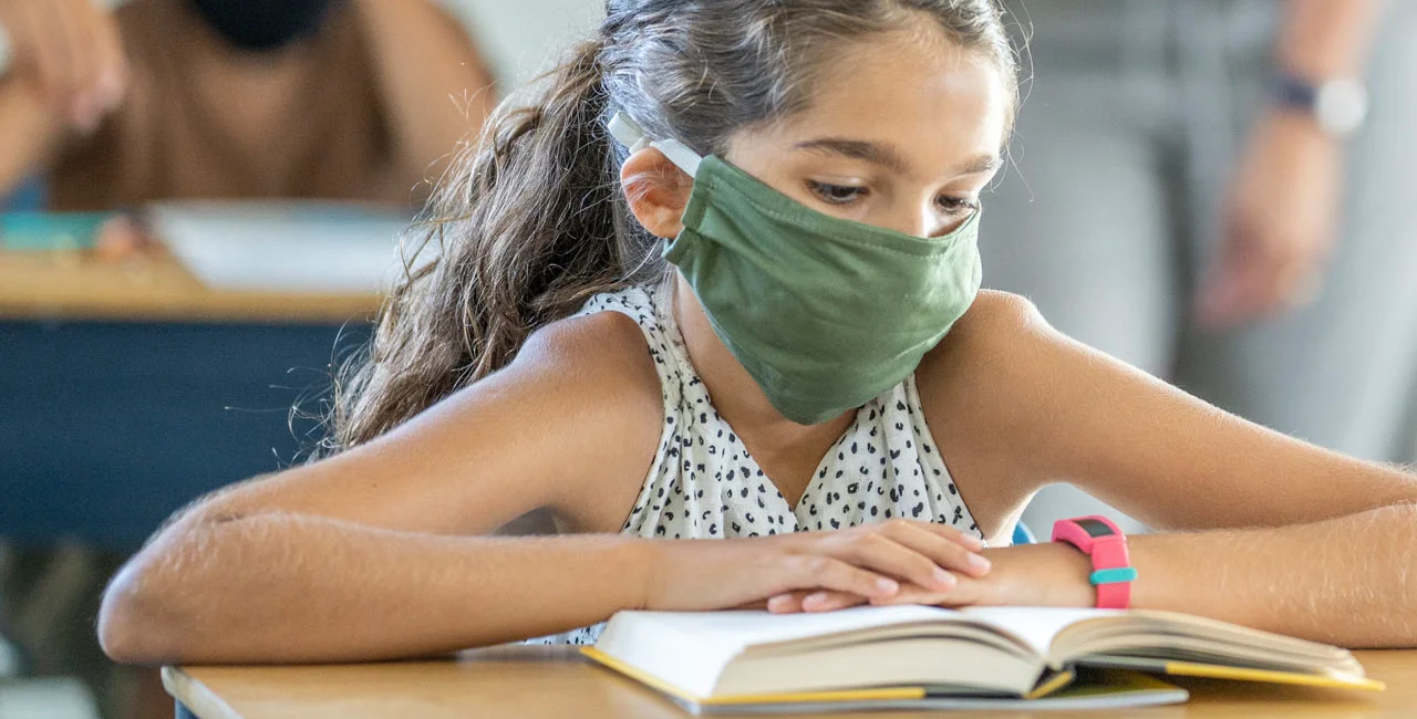 Students wearing face masks while in class via iStock / FatCamera