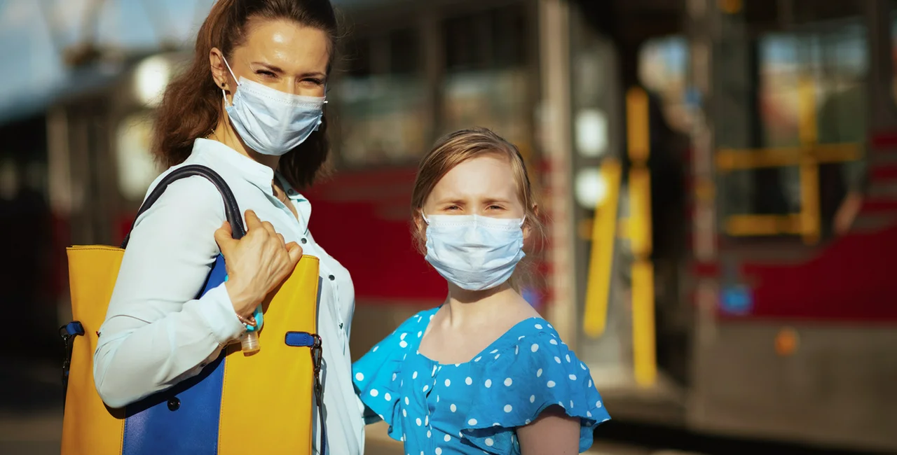 Mother and daughter weraring face masks in front of a Prague tram via iStock / CentralITAlliance