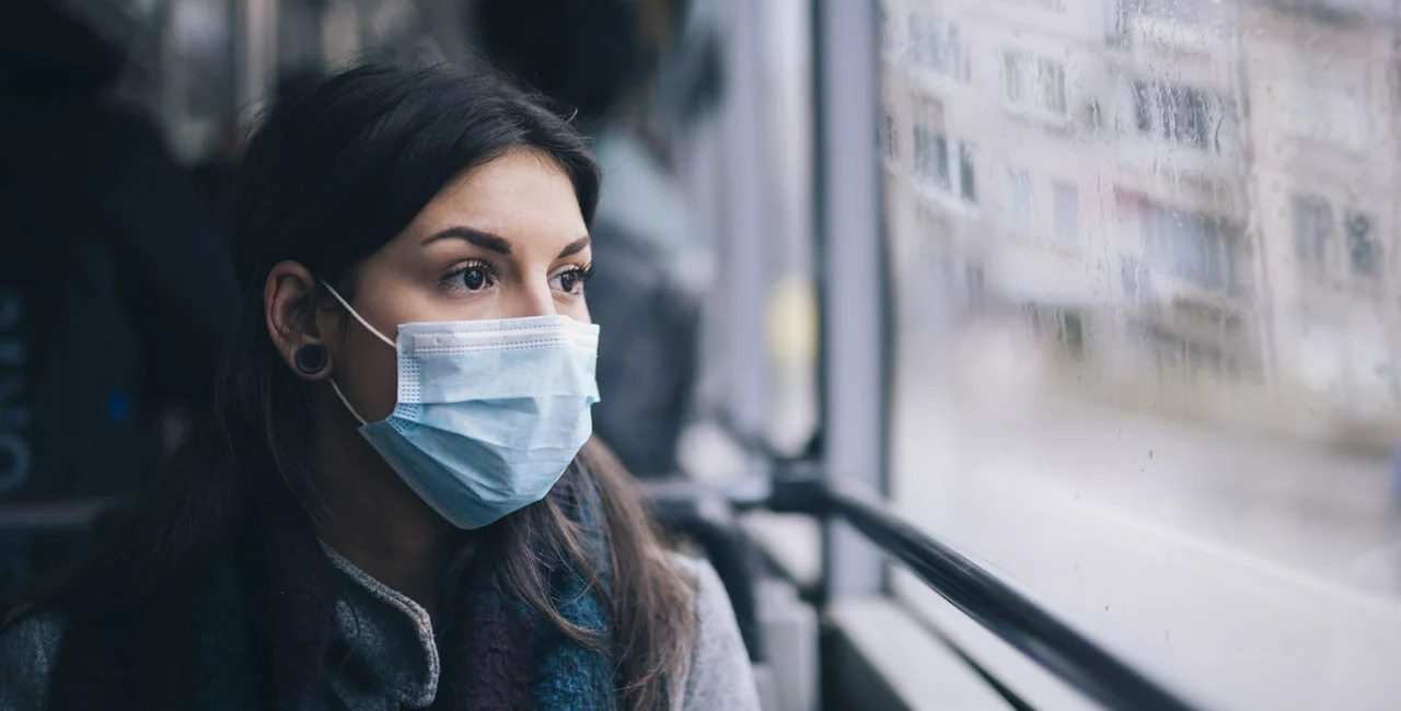 A woman wearing a mask in a bus. Photo: iStock/ArtistGNDphotography