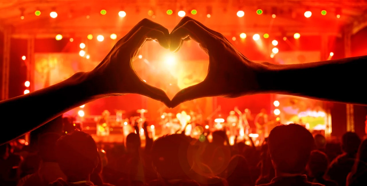 Crowd of Audience at during a concert with a heart shaped hands shadow