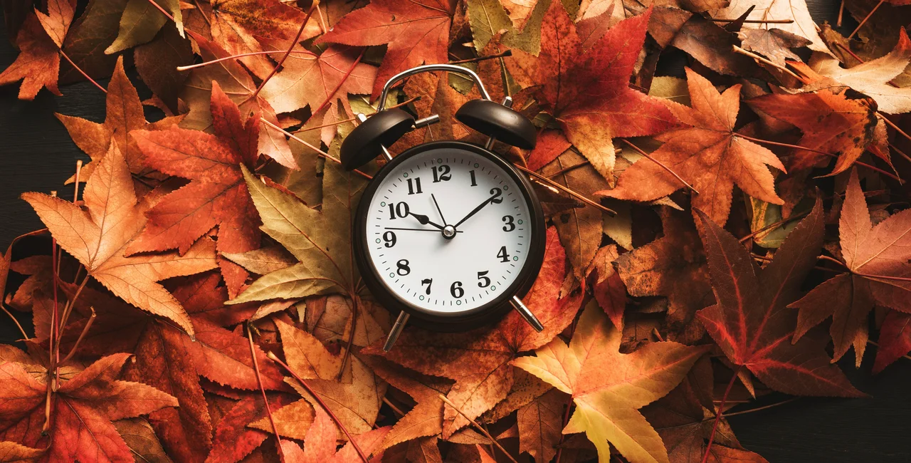 A clock nestled into fall leaves. Photo: iStock/stevanovicigor