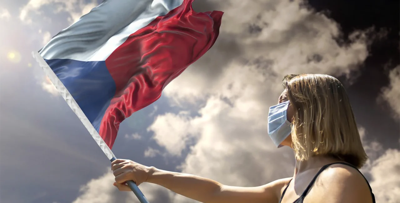 Woman with face mask holding Czech flag via iStock / MicroPixieStock