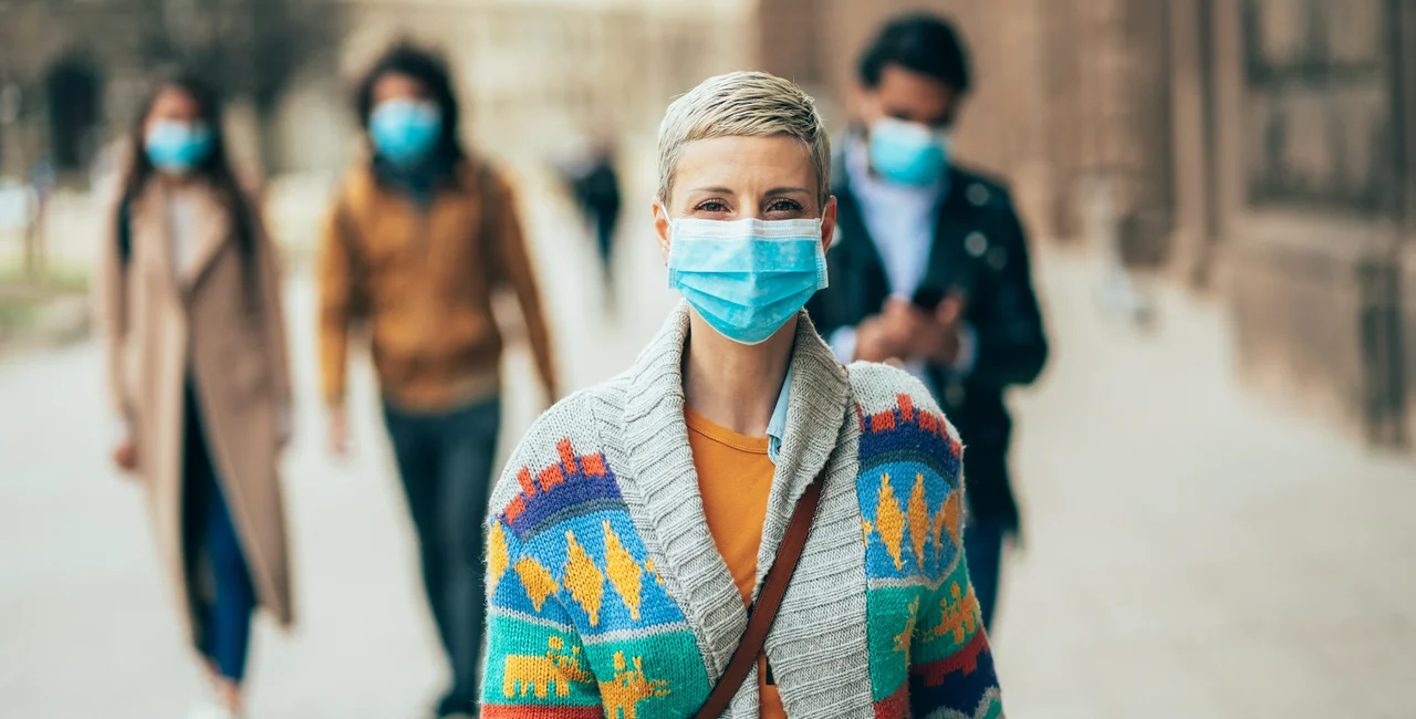 Woman wearing a face mask outdoors via iStock / filadendron
