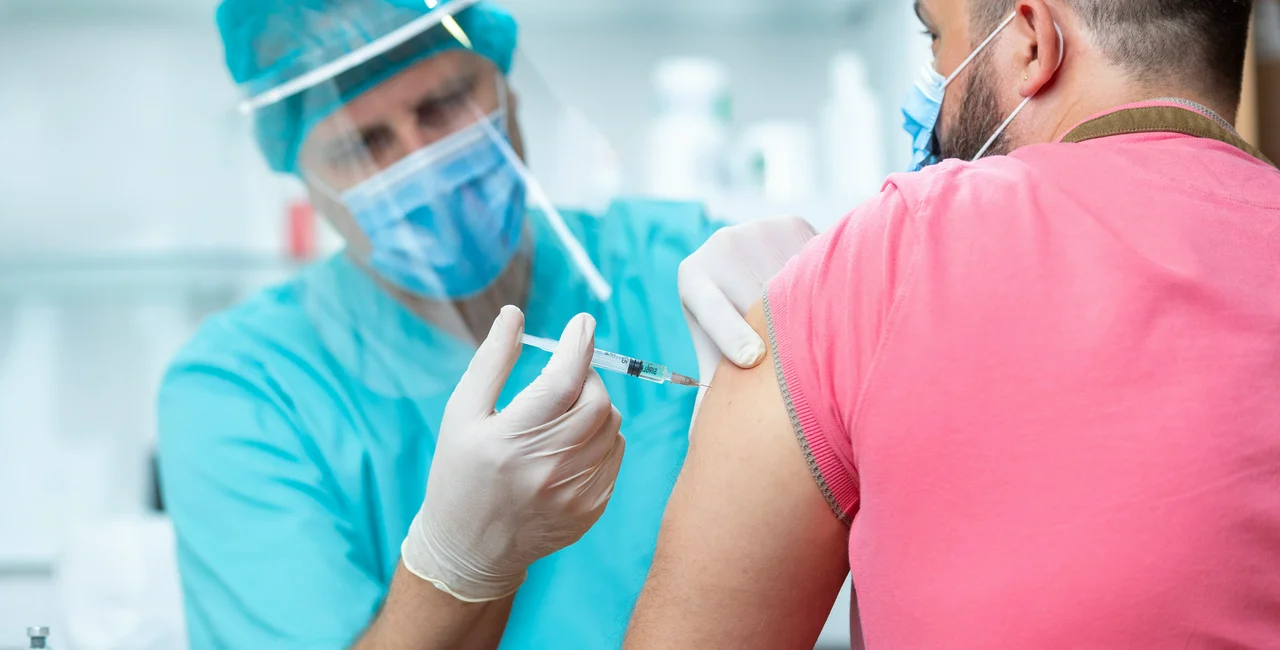 Hospital technician administering a vaccine via iStock / zoranm