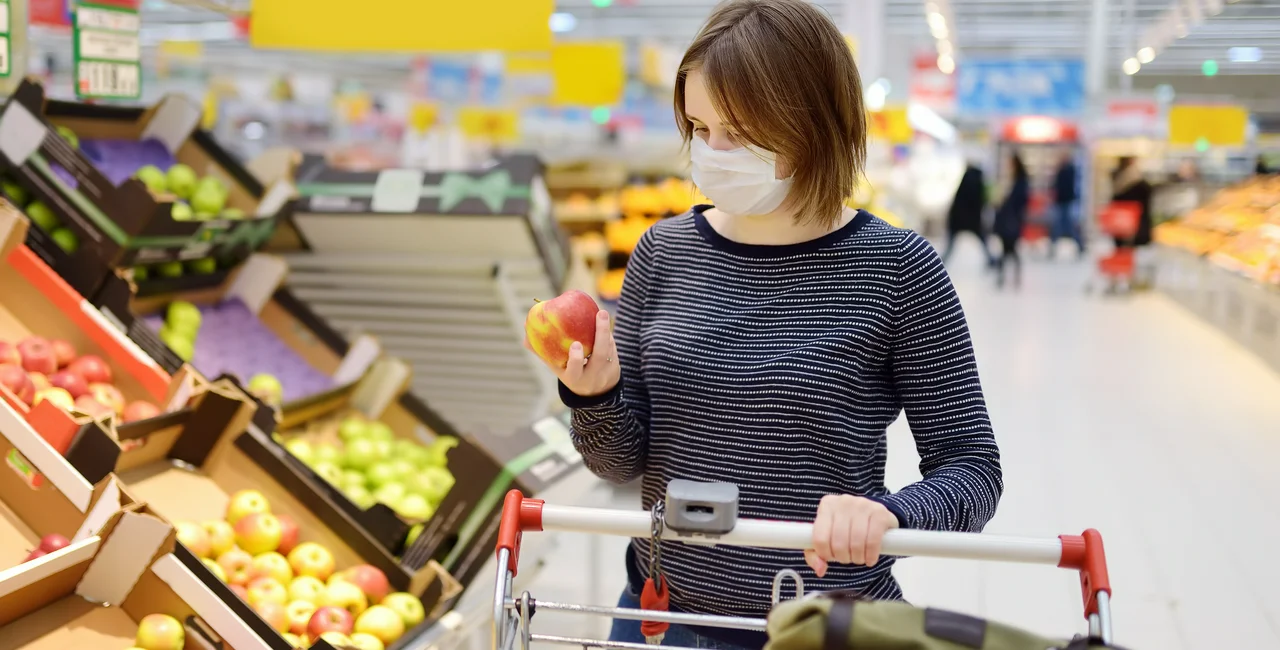 Young woman wearing a face mask in a supermarket via iStock / SbytovaMN