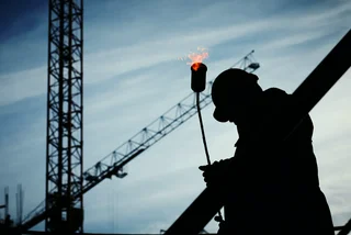 Worker with construction cranes and blow torch.  (photo: Pexels / yurykim)
