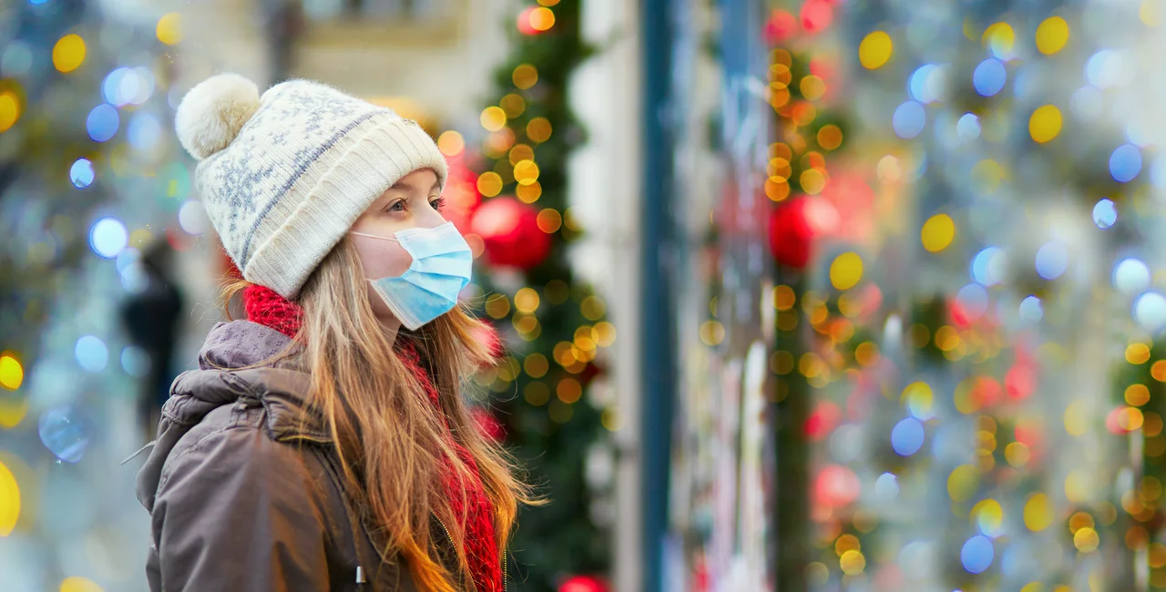 Girl wearing face mask during Christmas holiday season via iStock / encrier