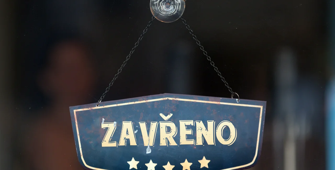Old fashioned sign in the window of a shop saying in Czech "Zavřeno", meaning in English "Closed" (photo iStock / Gwengoat) 