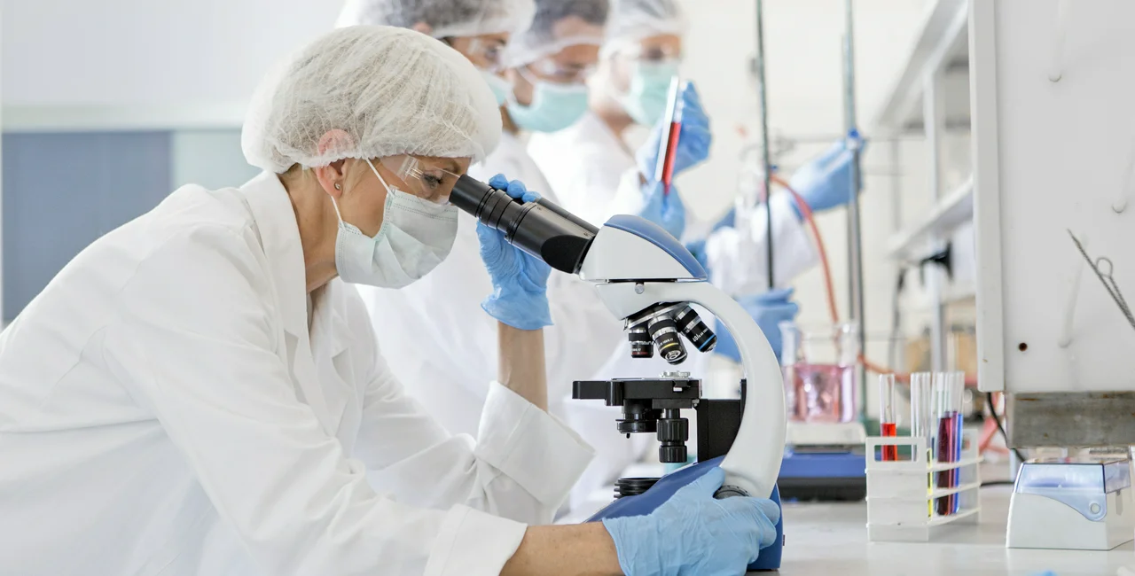 Scientists examine a virus in the laboratory, via iStock / Nastasic
