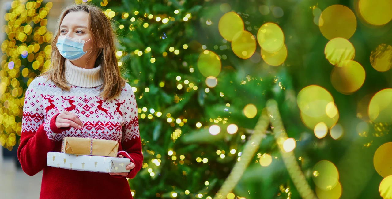 Woman with Christmas gifts and face mask via iStock / encrier