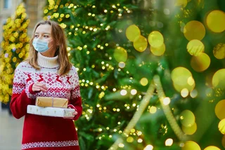Woman with Christmas gifts and face mask via iStock / encrier