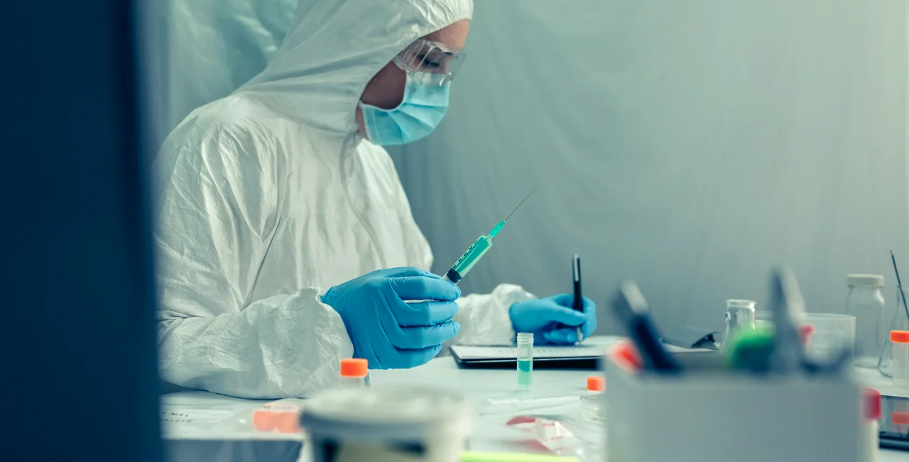 A lab worker checks samples.  (Photo via iStock, doble d)
