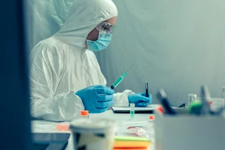 A lab worker checks samples.  (Photo via iStock, doble d)