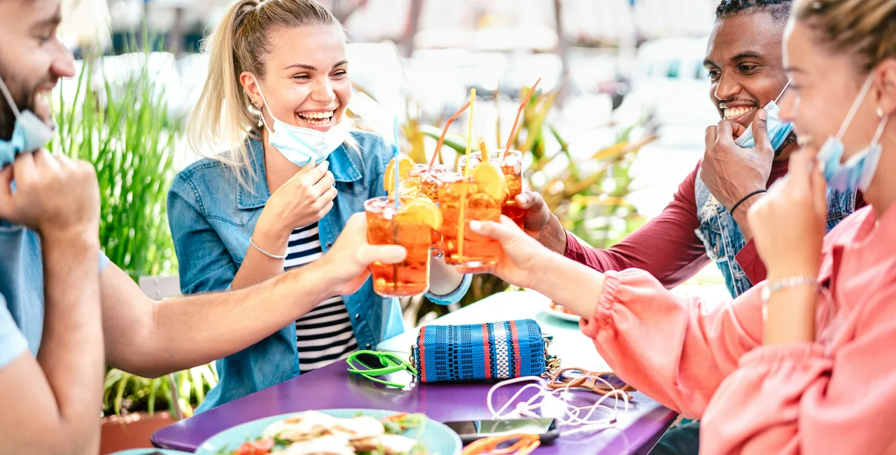 People with face masks  enjoy beverages at a restaurant garden. (Photo: iStock, ViewApart)