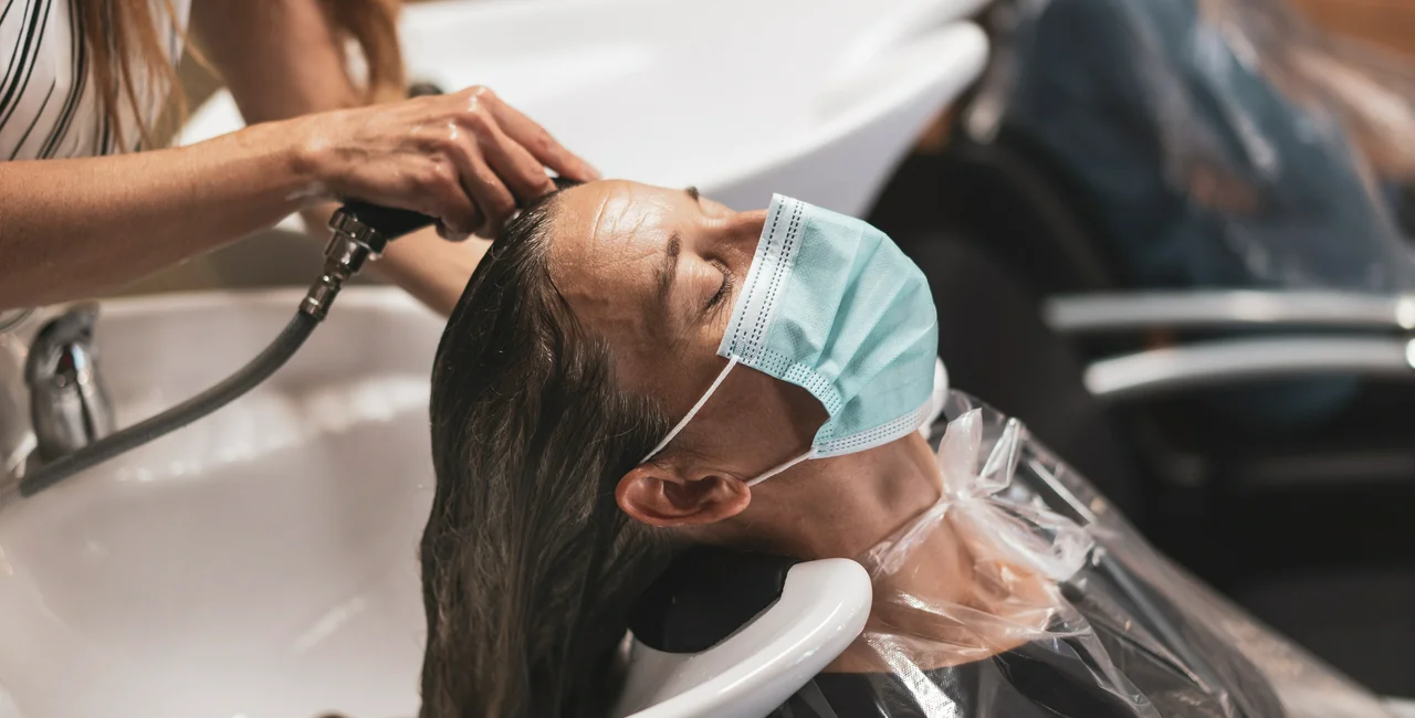 Woman with a face mask in a hair salon. (Photo: iStock, amriphoto)