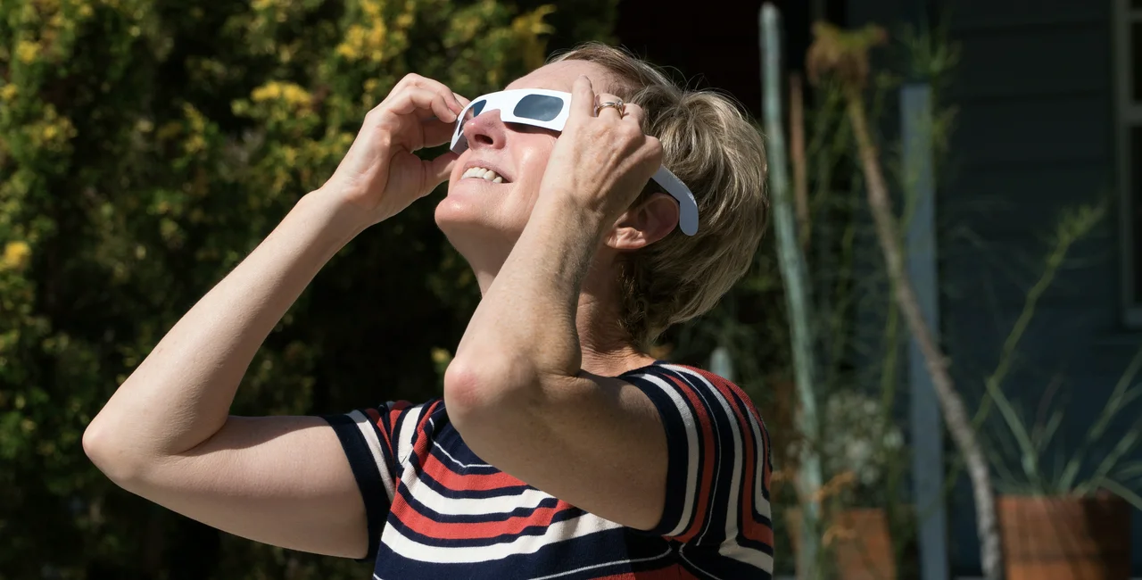 Person watching an eclipse with paper-frame viewing glasses. (Photo: iStock, Spiderplay)