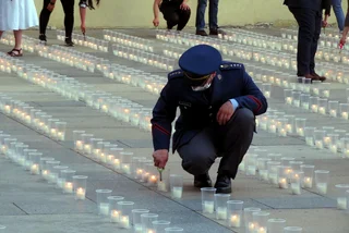 A soldier lights one of 30,000 candles at Prague Castle for people who died of Covid. (Photo: Raymonf johnston)