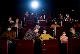eople wearing protective face masks while watching movies at the cinema. (Photo: iStock, RgStudio)