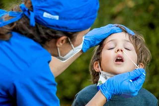 Nurse performing a Covid-19 test on a boy before going back to school. (Photo: iStock, Juanmonino)