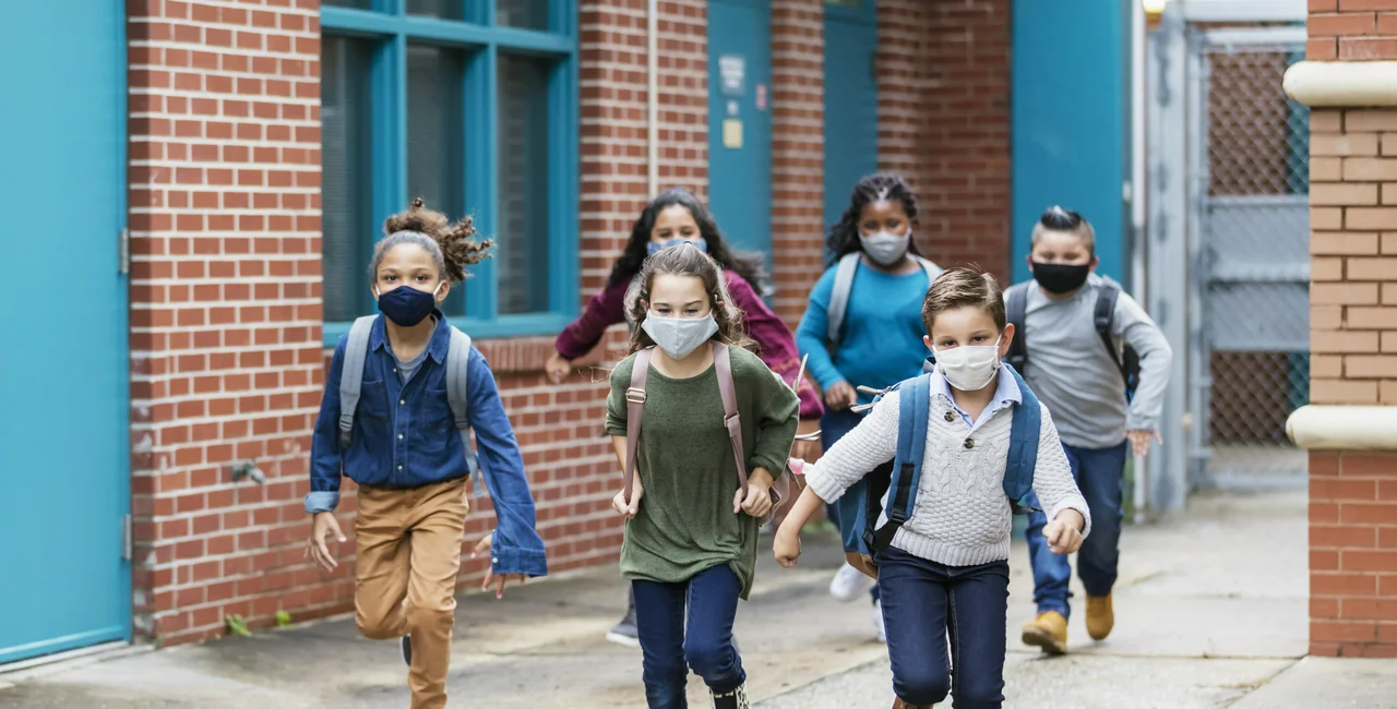 Children wearing masks outside a school. (Photo: iStock, kali9)