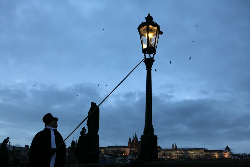 Lamplighter on Charles Bridge in Prague. Photo: iStock / wrangel