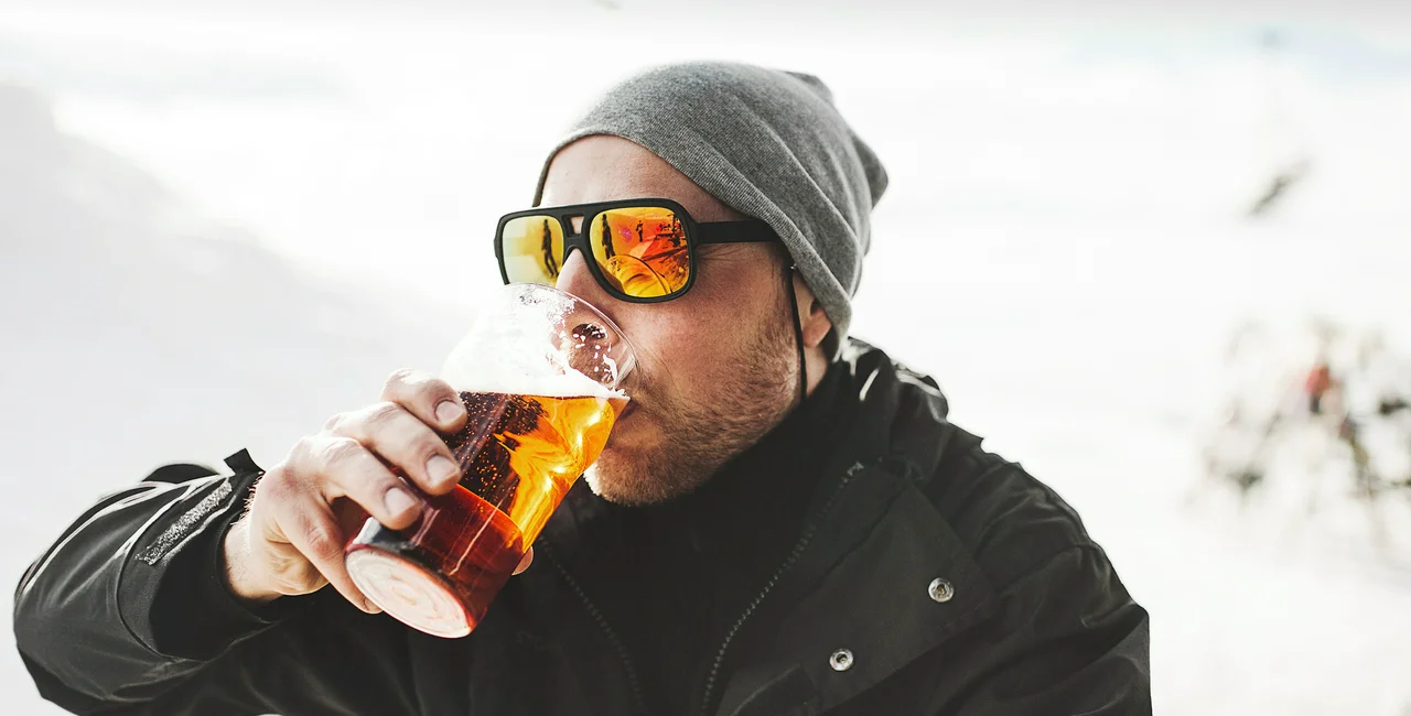 Man drinking a beer at a ski resort. Photo: iStock / knape
