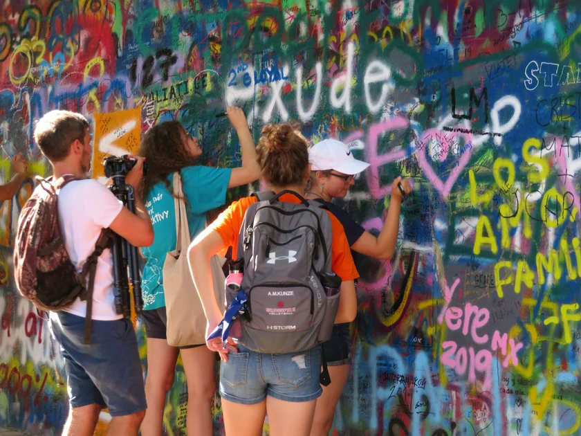 Tourists writing on the Lennon Wall in early 2019. Photo: Raymond Johnston.