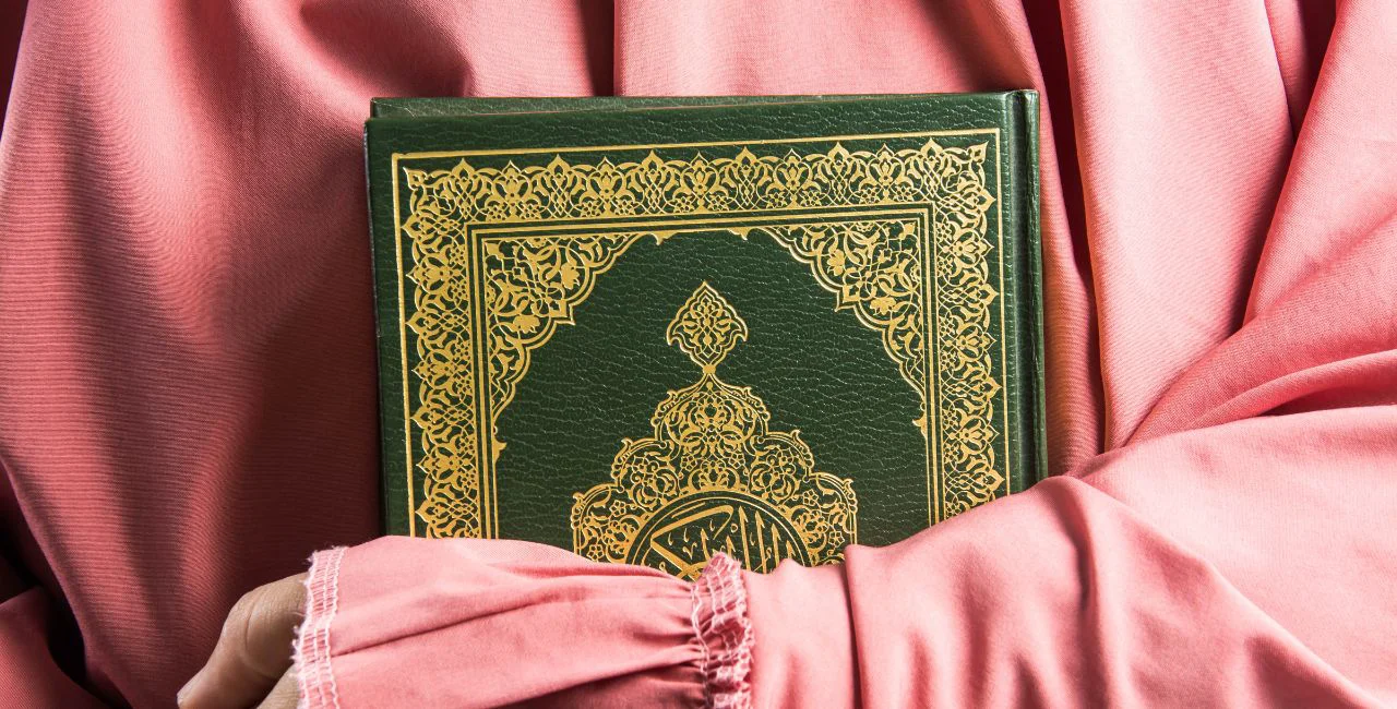Illustrative image of woman holding Koran / meen_na from Getty Images