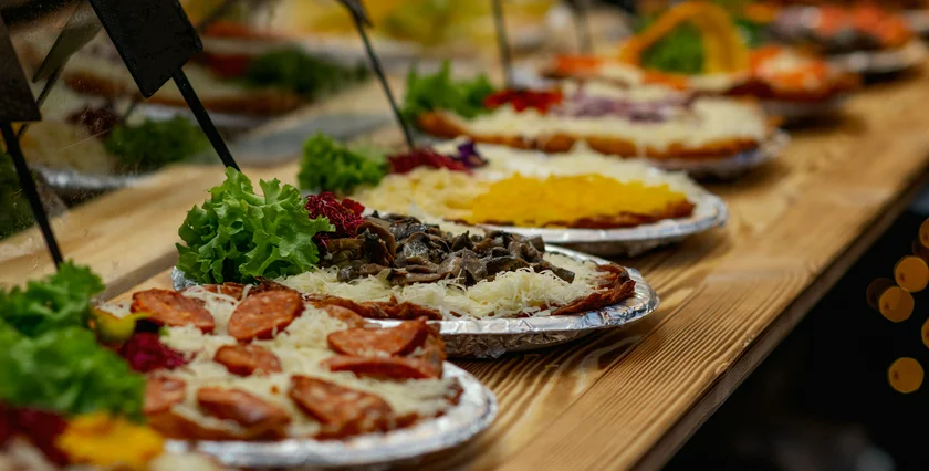 shutterstock_2705834441 Delicious Hungarian langos with various toppings enjoyed at a festive Christmas market, offering authentic street food experience JPG