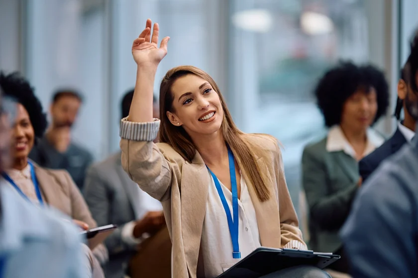 shutterstock_2571097767 conf conference raise hand asking business woman